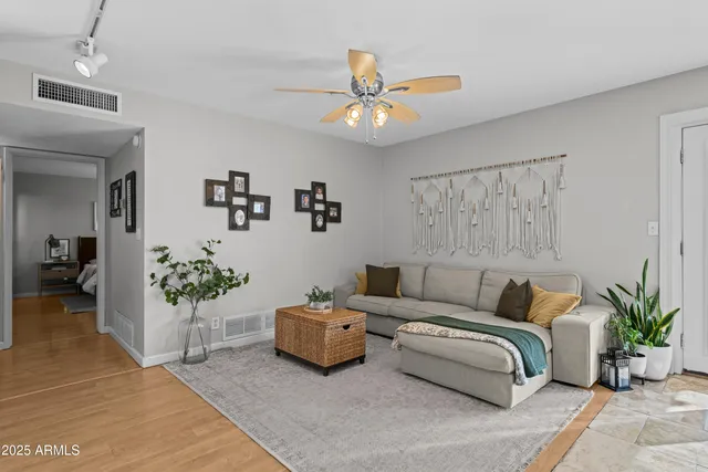 a living room with furniture and flower plants