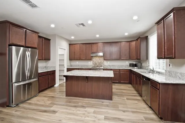 a kitchen with granite countertop a refrigerator and a sink