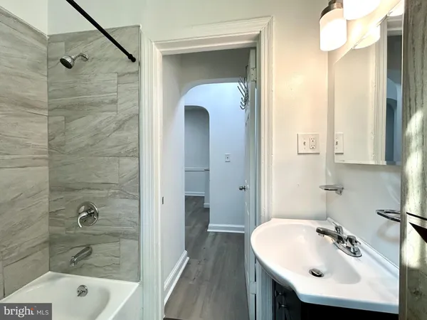 a bathroom with a sink a shower and a mirror