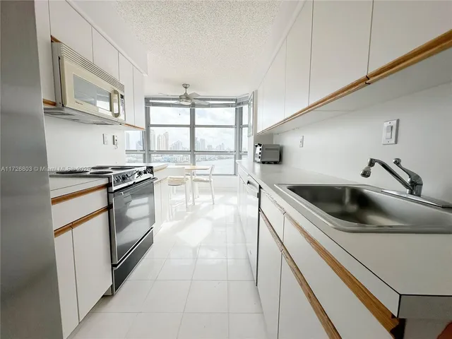 a kitchen with granite countertop a sink a stove and cabinets