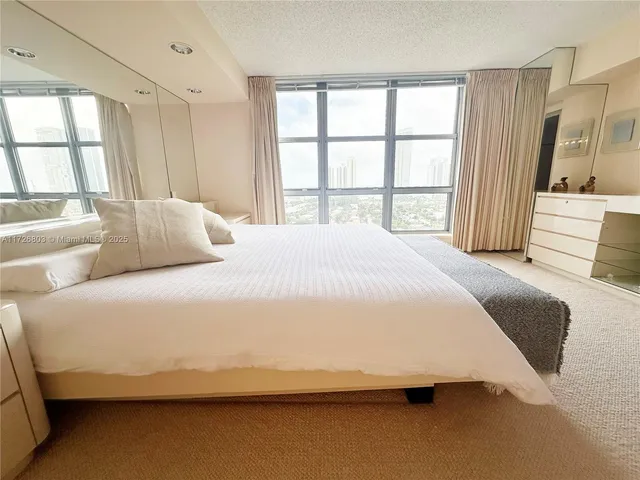 a bedroom with a bed and a large window