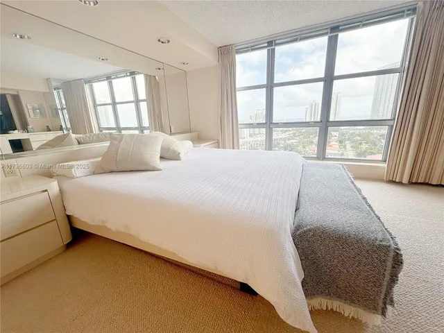 a large bed sitting in a bedroom next to a window