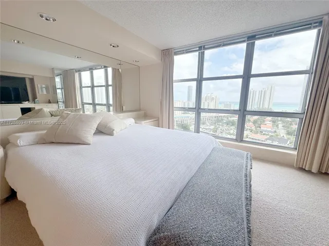 a large bed sitting in a bedroom next to a window