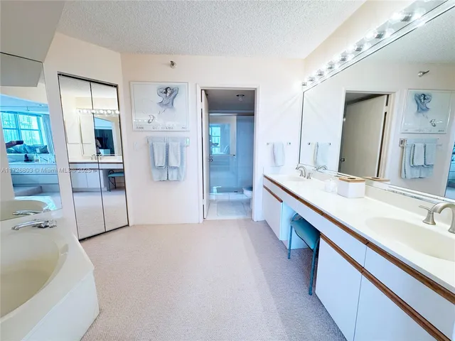 a spacious bathroom with a double vanity sink a mirror and a bathtub