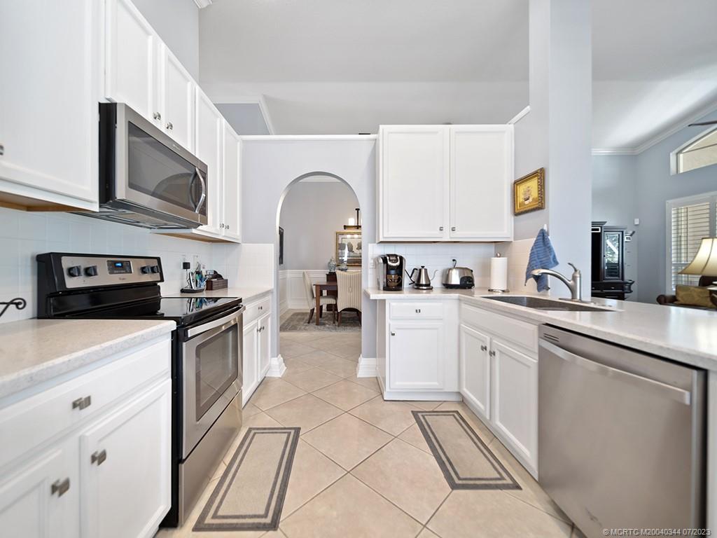 1136 Southeast Westminster Place Stuart, FL 34997 - Photo 17 of 36 a kitchen with stainless steel appliances granite countertop a stove a sink and a microwave