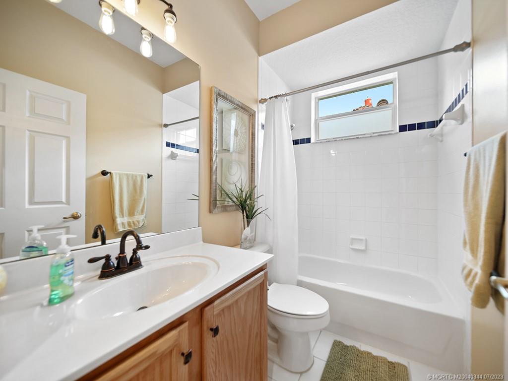 1136 Southeast Westminster Place Stuart, FL 34997 - Photo 20 of 36 a bathroom with a sink a toilet and shower