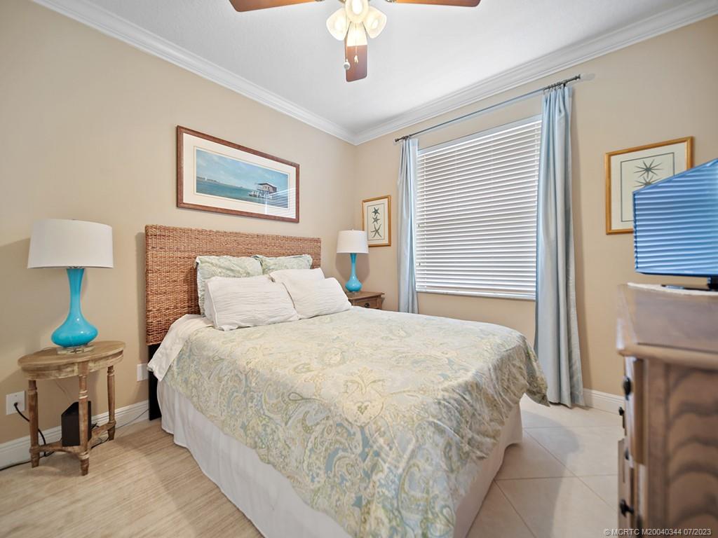 1136 Southeast Westminster Place Stuart, FL 34997 - Photo 21 of 36 a bedroom with bed and a chandelier