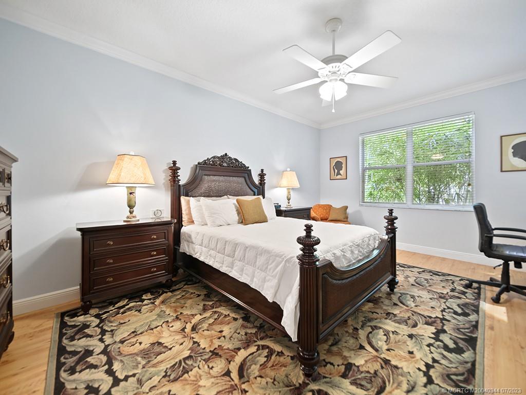 1136 Southeast Westminster Place Stuart, FL 34997 - Photo 23 of 36 a bed room with a bed and a chandelier