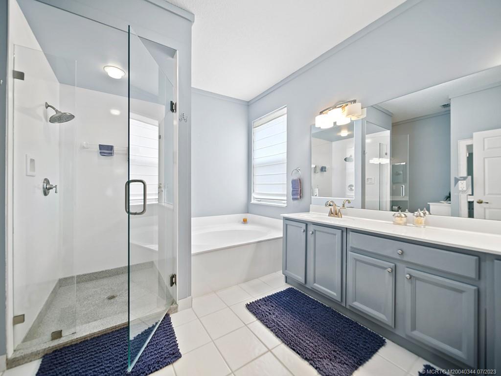 1136 Southeast Westminster Place Stuart, FL 34997 - Photo 25 of 36 a spacious bathroom with a shower sink mirror and a bathtub