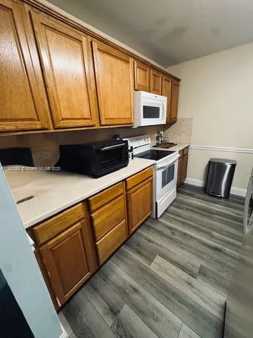 a kitchen with a refrigerator and a stove top oven