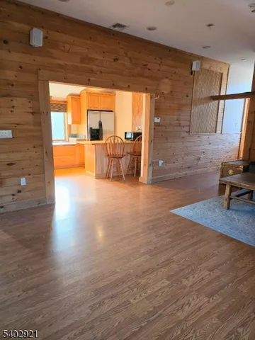 a living room with furniture floor to ceiling window and wooden floor