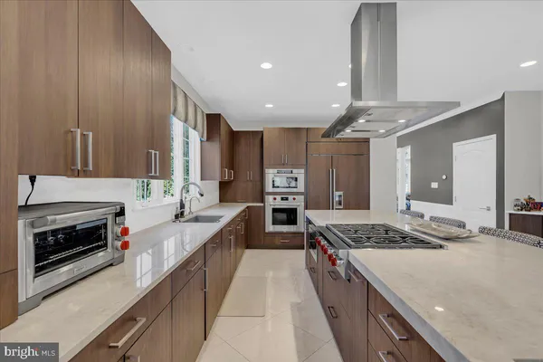 a large kitchen with stainless steel appliances granite countertop a stove and a refrigerator