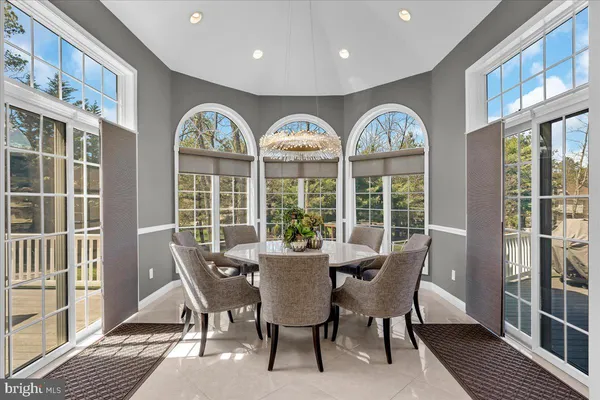 a view of a dining room with furniture large windows and wooden floor