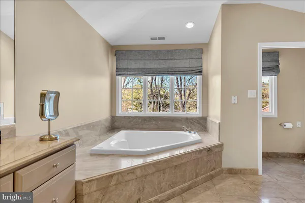 a bathroom with a granite countertop sink and a bathtub