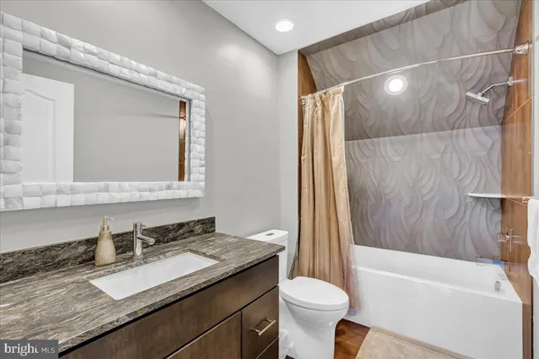 a bathroom with a granite countertop sink toilet and shower