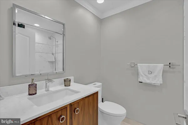 a bathroom with a sink toilet vanity and shower