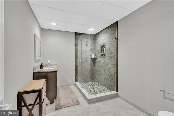 a bathroom with a sink a toilet a mirror and shower
