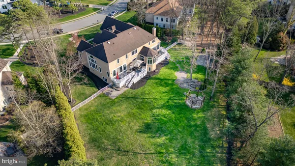 an aerial view of residential house with outdoor space and trees all around
