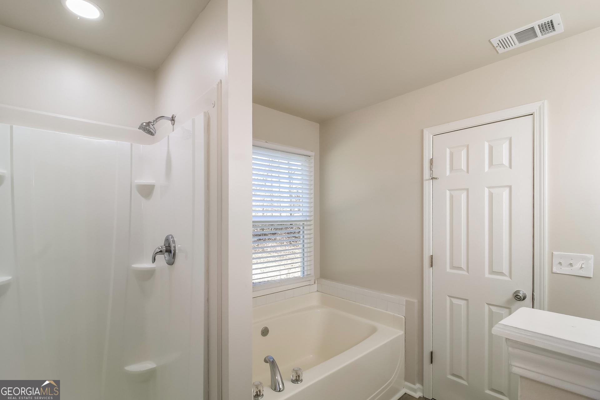 355 Freeman Drive Covington, GA 30016 - Photo 12 of 17 a bathroom with a bathtub and a shower