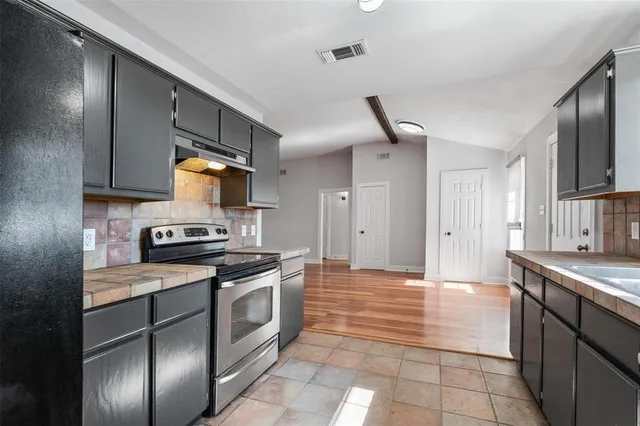a kitchen with stainless steel appliances granite countertop a stove a sink and a refrigerator