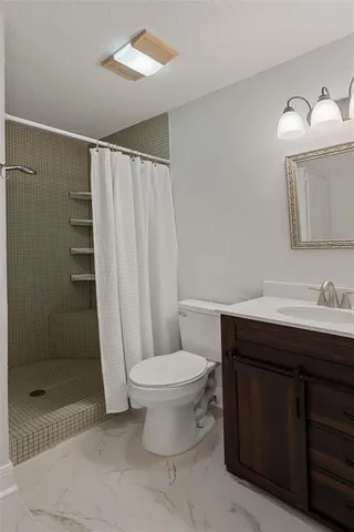 an empty room with wooden floor cabinet and windows