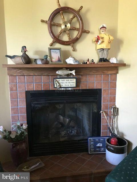 2700 Elsey Road Nanticoke, MD 21840 - Photo 14 of 43 a fireplace with a clock and a lamp