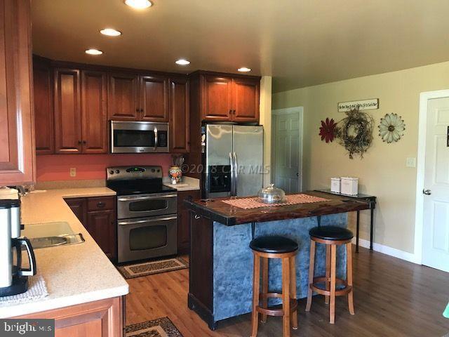 2700 Elsey Road Nanticoke, MD 21840 - Photo 8 of 43 a kitchen with kitchen island granite countertop wooden cabinets and stainless steel appliances