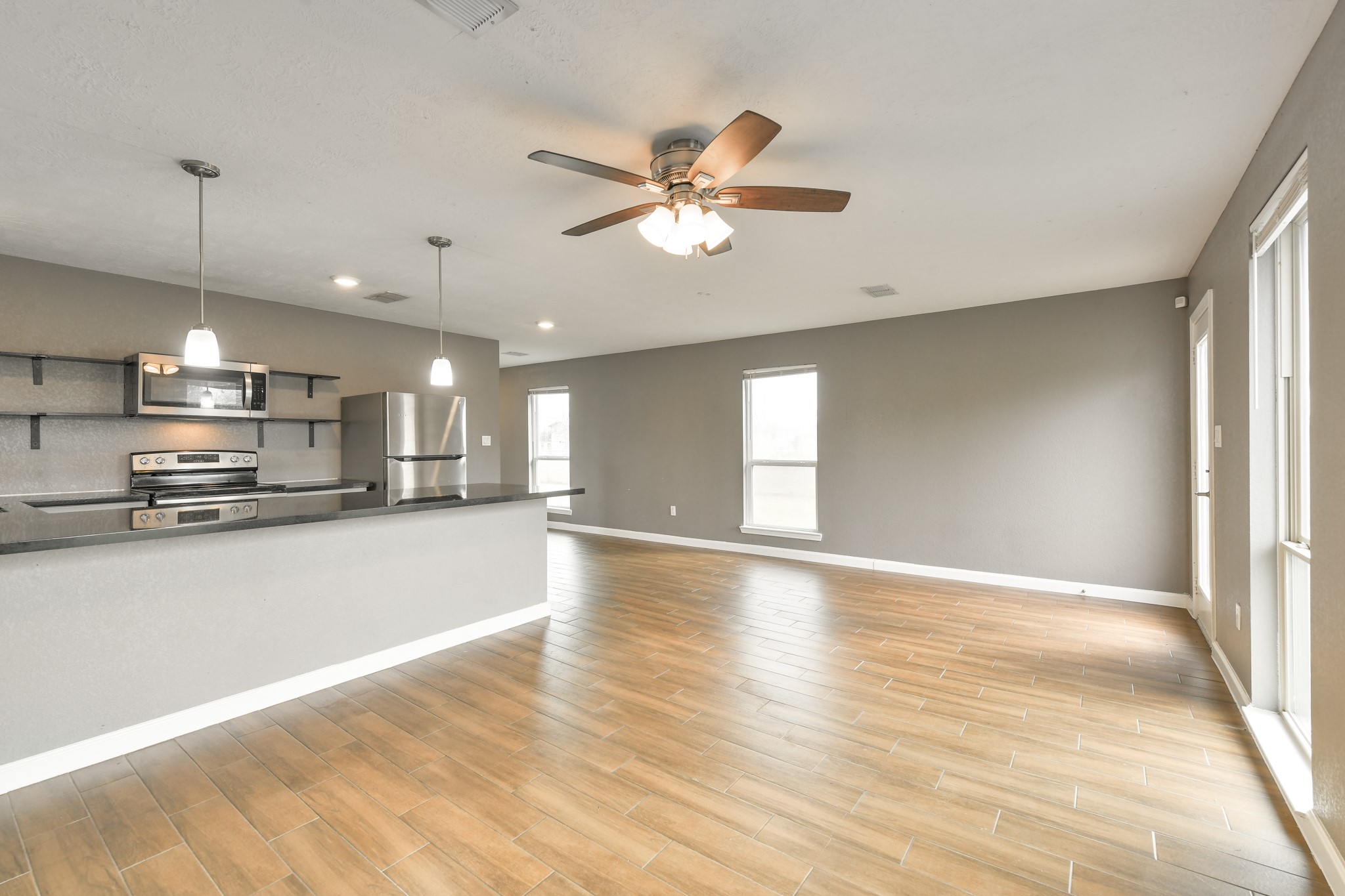1210 Airline North Rosharon, TX 77583 - Photo 8 of 19 a view of a kitchen with a stove cabinets a ceiling fan and wooden floor