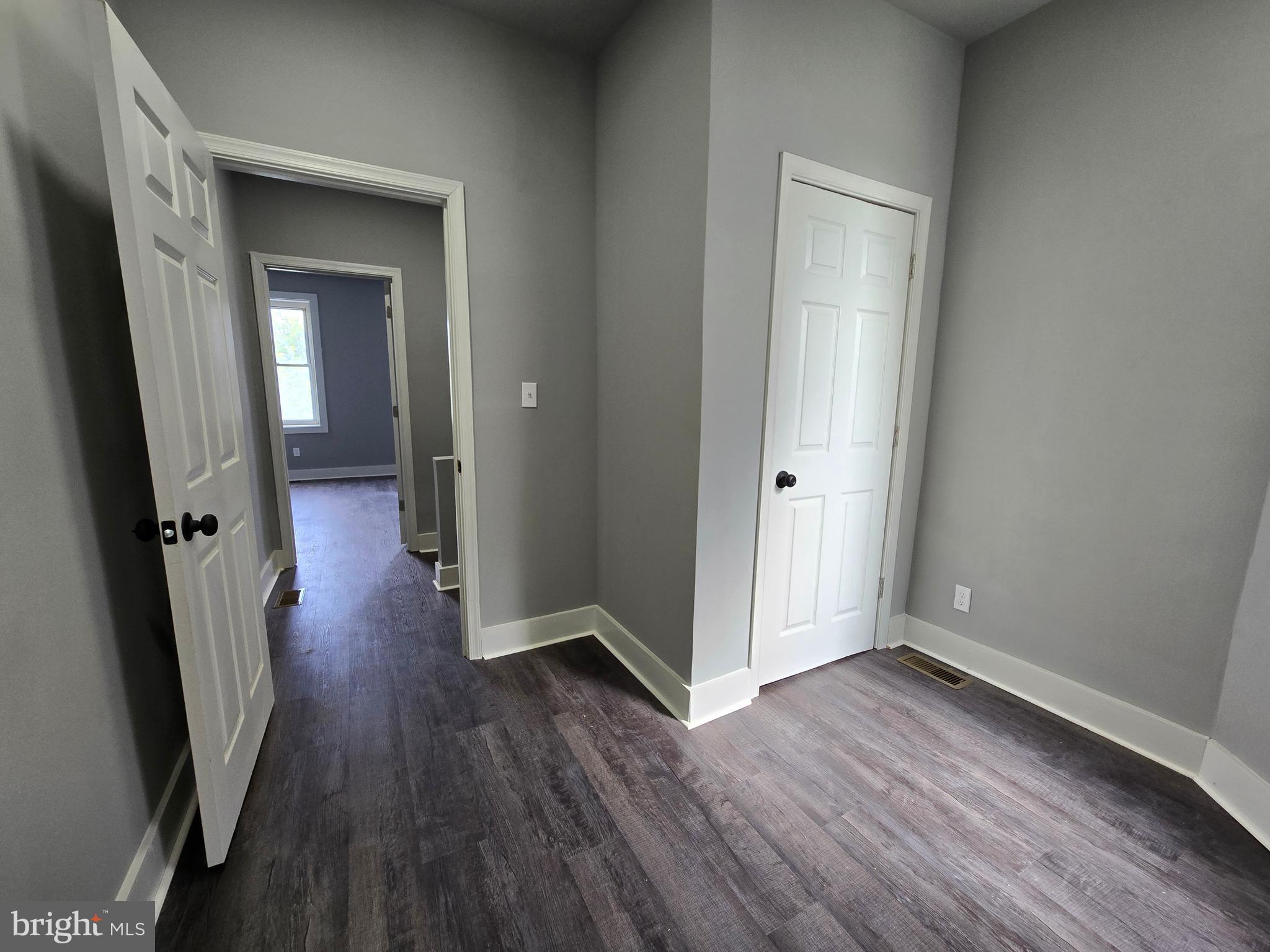 2811 East Preston Street Baltimore, MD 21213 - Photo 13 of 28 an empty room with wooden floor and a hallway
