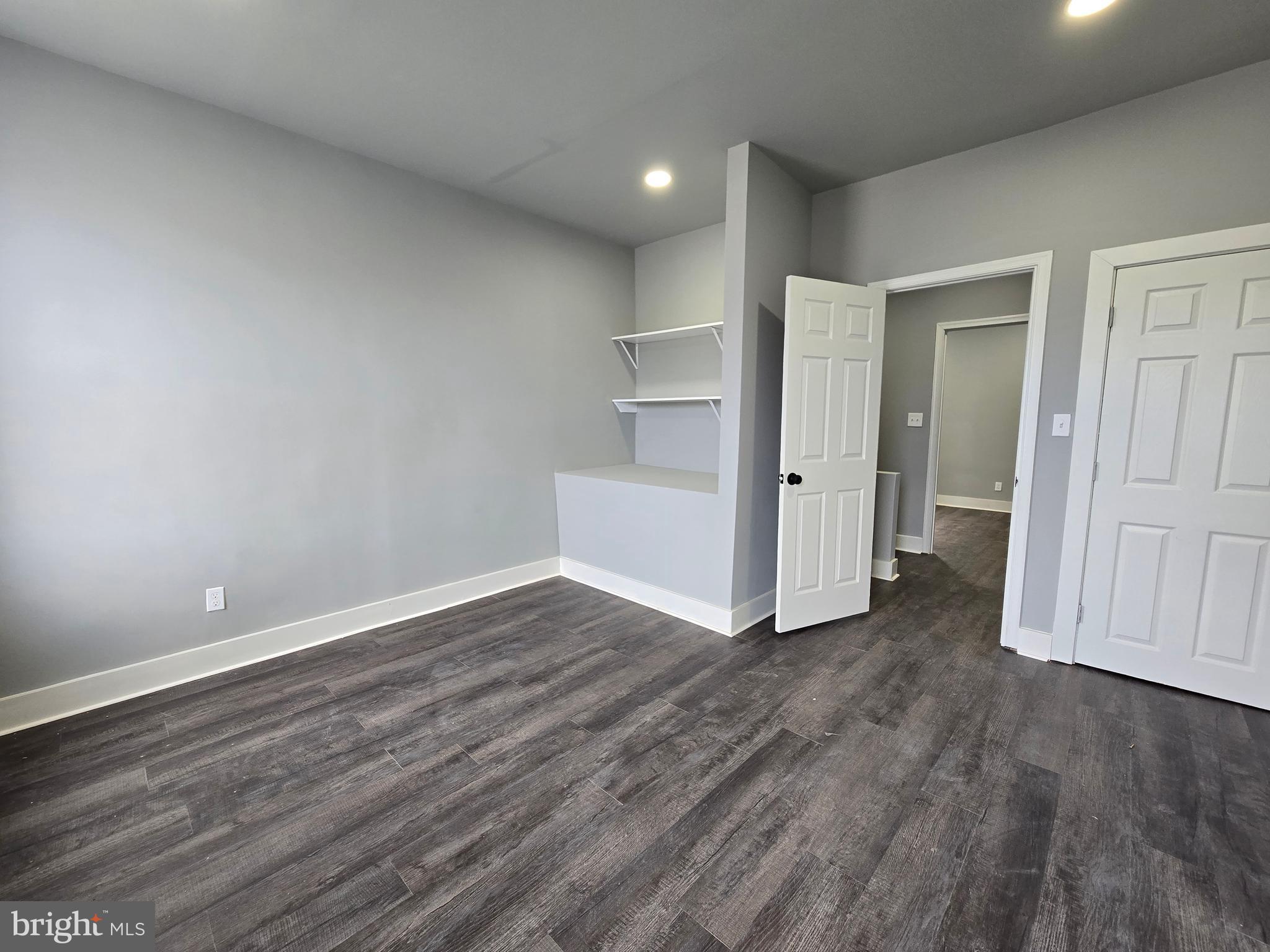 2811 East Preston Street Baltimore, MD 21213 - Photo 16 of 28 an empty room with wooden floor & windows and bathroom