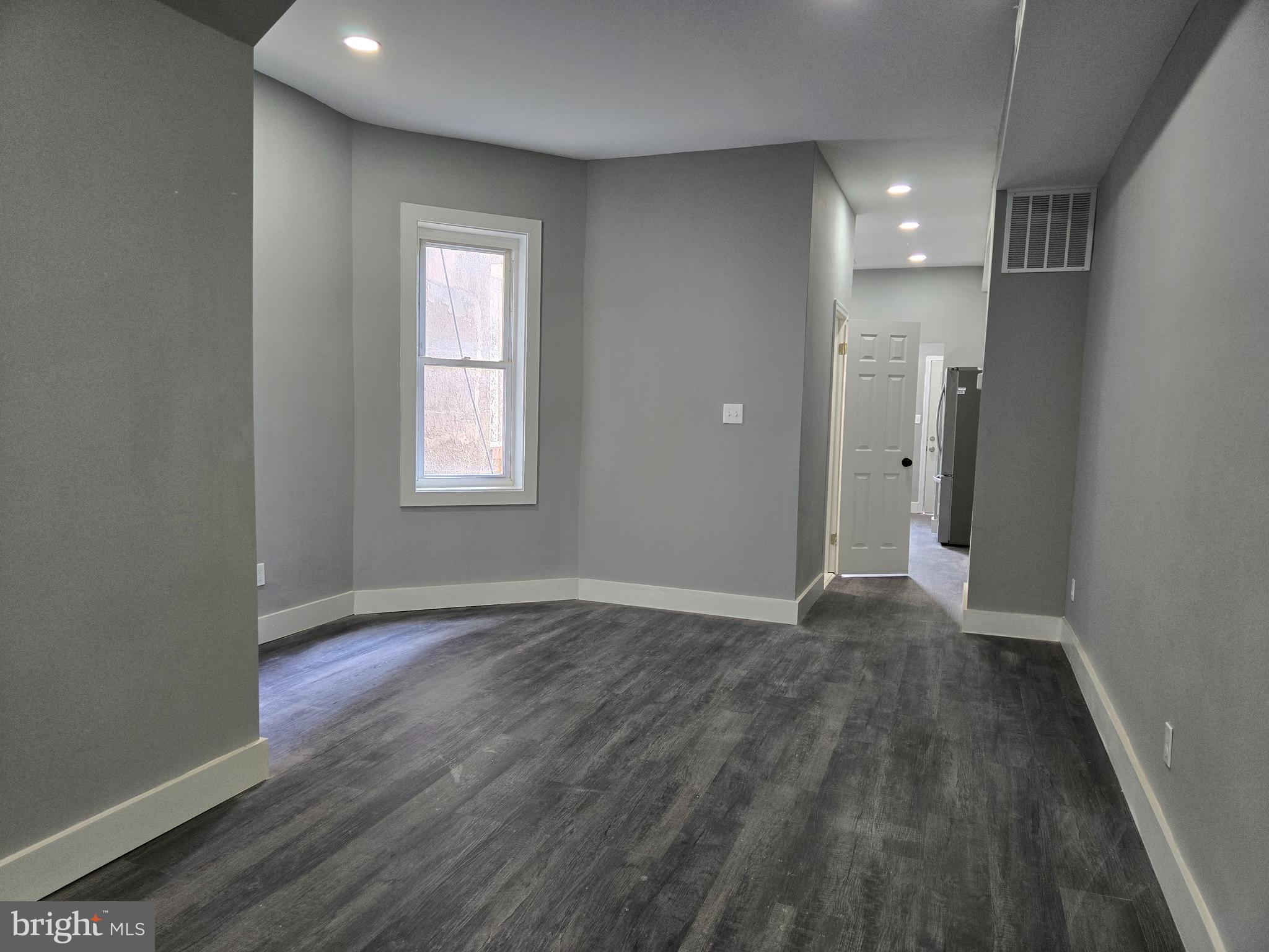 2811 East Preston Street Baltimore, MD 21213 - Photo 9 of 28 an empty room with wooden floor and windows