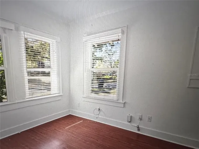 a view of an empty room with wooden floor