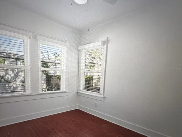 a view of an empty room with wooden floor