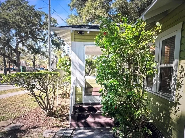 a front view of a house with a tree