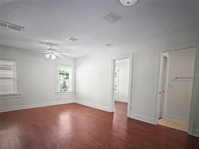 a view of empty room with wooden floor