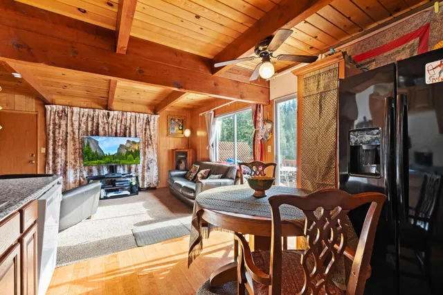 a view of a dining room with furniture a chandelier and large windows