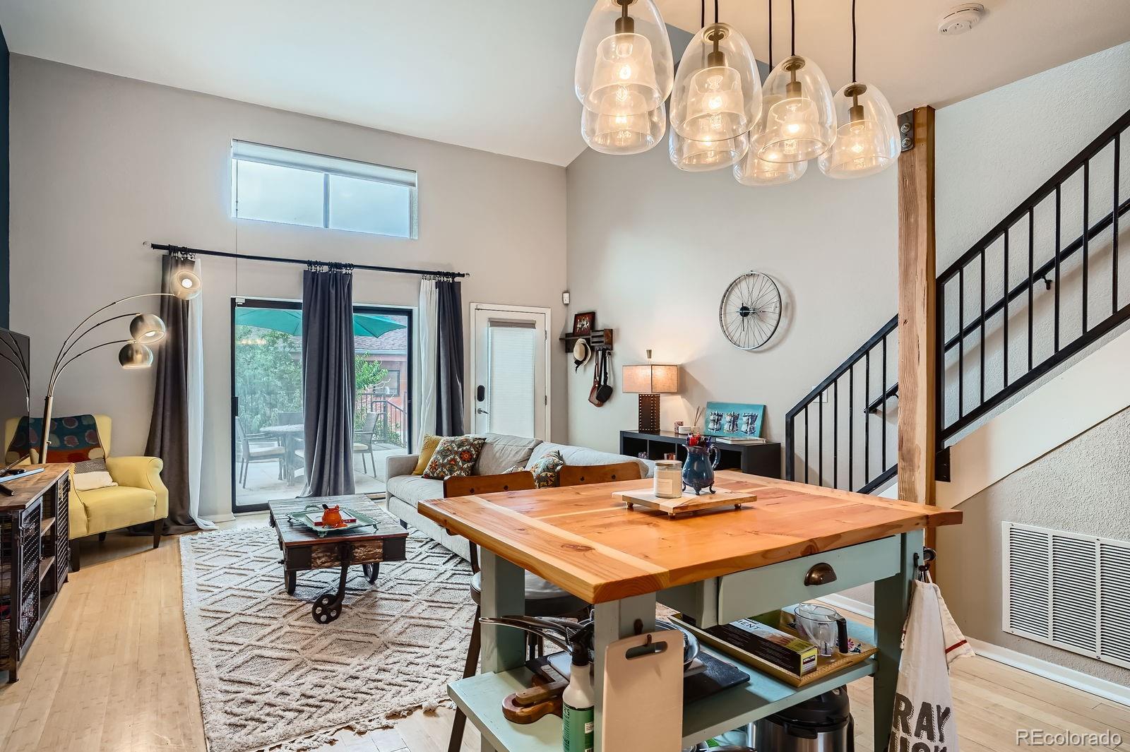 3295 Blake Street, Unit 202 Denver, CO 80205 - Photo 14 of 39 a dining room with wooden floor a chandelier a wooden table and chairs