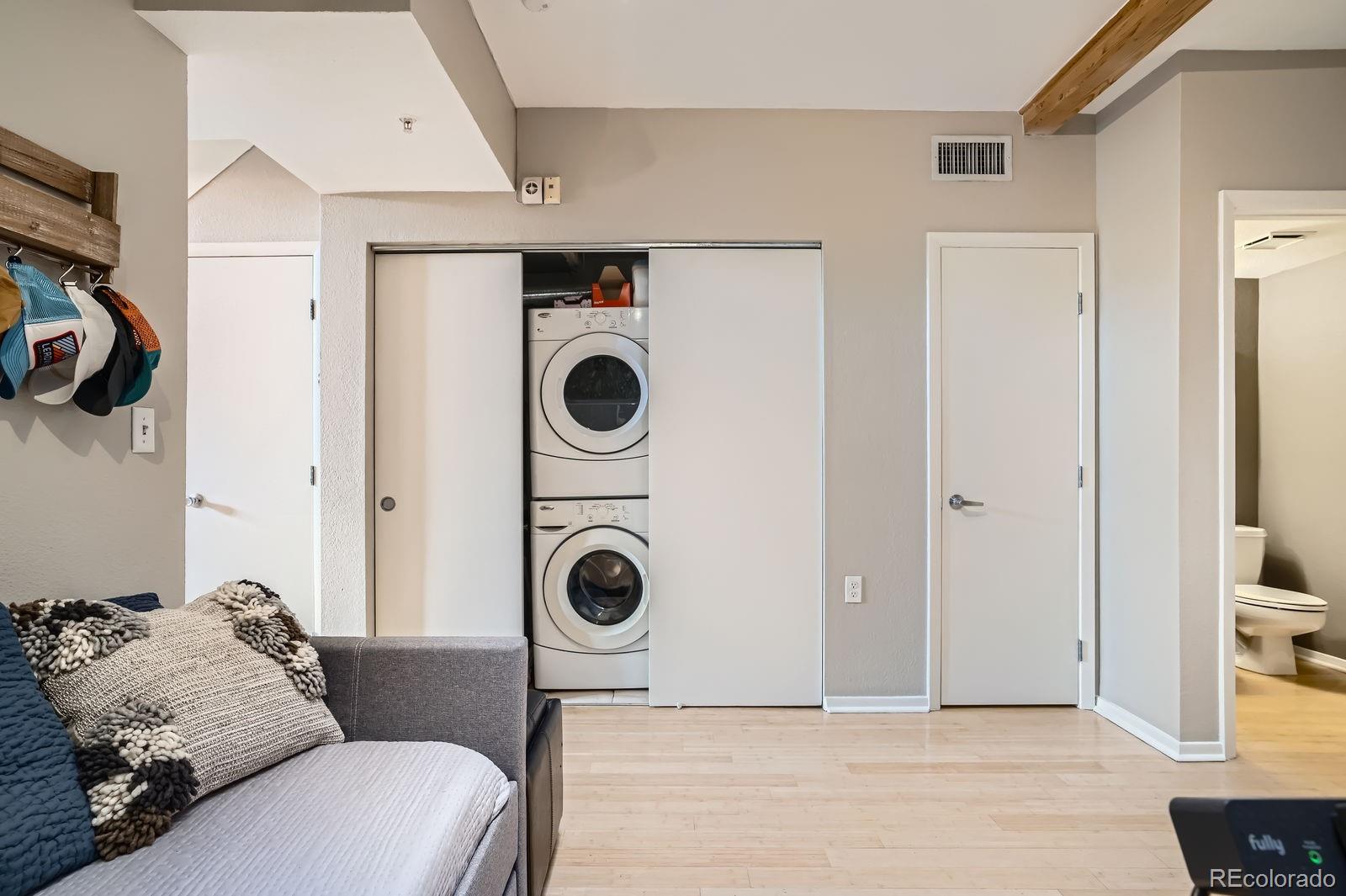 3295 Blake Street, Unit 202 Denver, CO 80205 - Photo 22 of 39 a living room with a couch and a washer dryer