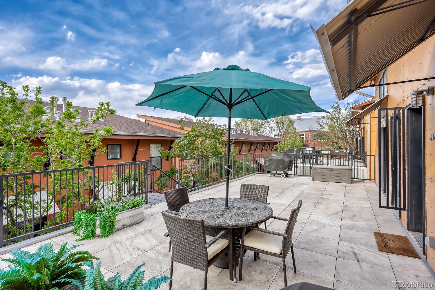 3295 Blake Street, Unit 202 Denver, CO 80205 - Photo 7 of 39 a view of a patio with a table and chairs under an umbrella
