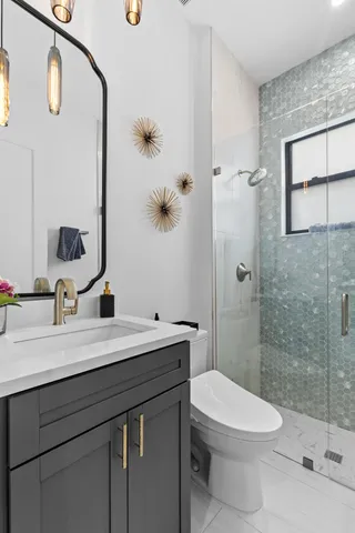 a living room with couches and kitchen view with wooden floor