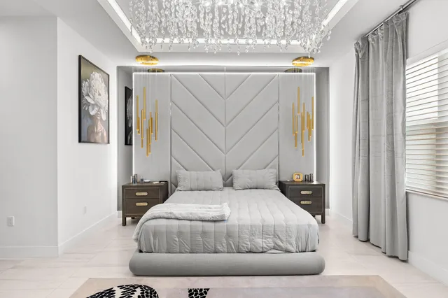 a bedroom with a large bed and a chandelier