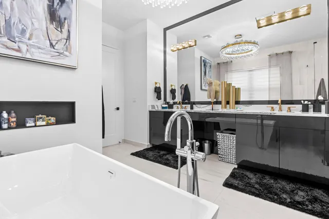 a spacious bedroom with a bed and a chandelier