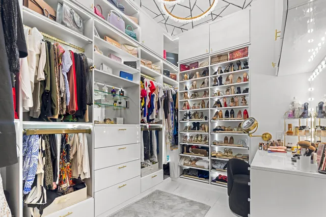 a bedroom with a large bed and a chandelier