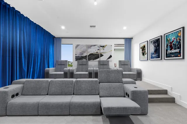 a view of a backyard with couches chair and floor to ceiling window next to a yard