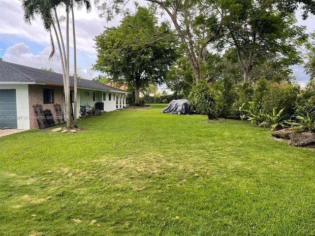 a backyard of a house with table and chairs