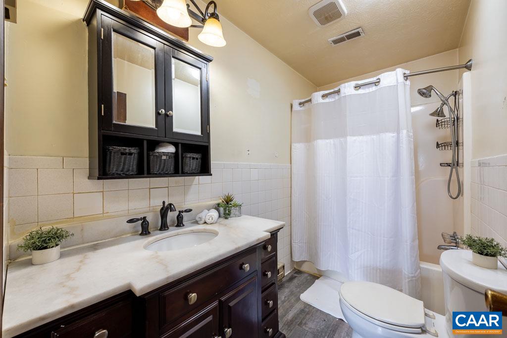9 Old Durrette Road Stanardsville, VA 22973 - Photo 11 of 46 a bathroom with a granite countertop sink toilet a mirror a vanity and shower