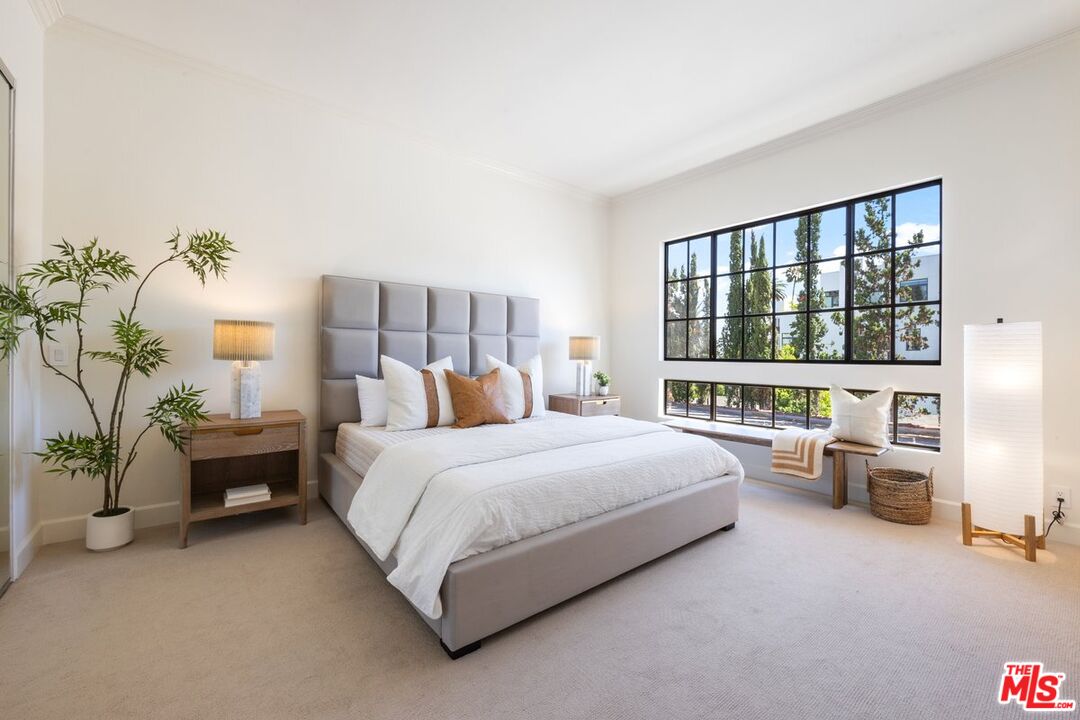 457 North Doheny Drive, Unit 304 Beverly Hills, CA 90210 - Photo 15 of 32 a bedroom with a bed couch and a large window