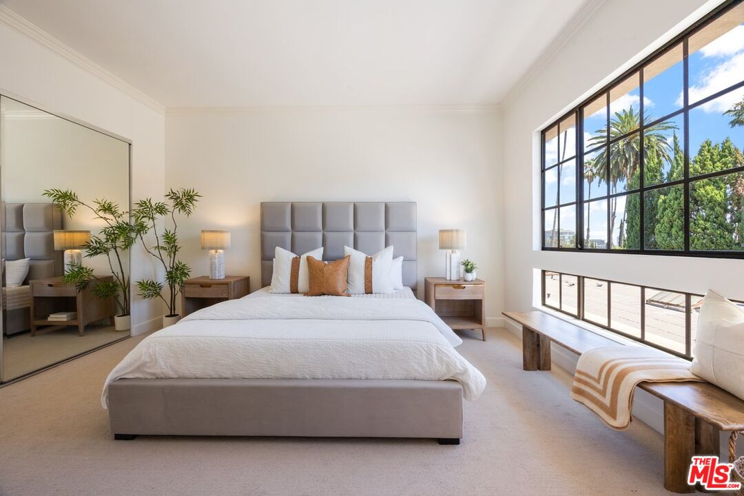 457 North Doheny Drive, Unit 304 Beverly Hills, CA 90210 - Photo 16 of 32 a bedroom with a large bed and a large window