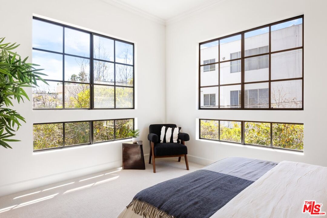 457 North Doheny Drive, Unit 304 Beverly Hills, CA 90210 - Photo 22 of 32 a bedroom with a bed and a large window