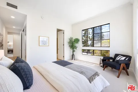 a bedroom with a bed and a large window